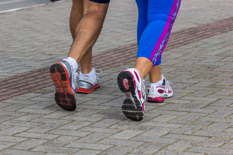 People jogging on a city street, giving a close-up of their sportswear shoes. Urban fitness scene.